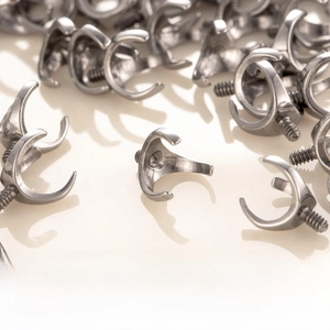 Macro detail of F136 titanium three-claw ball base with 0.9mm screw head piercing part