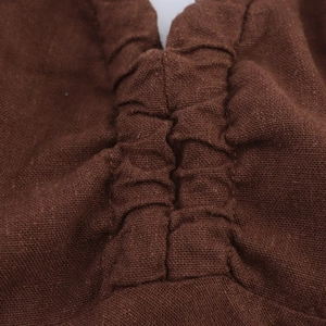 Macro shot of brown linen-blend fabric with detailed pleated stitching and texture