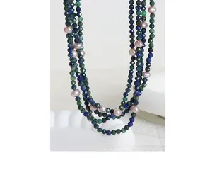 Macro view of multi-layered necklace with faceted blue stones and pinkish pearls