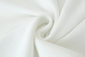 Détail macro de la texture du tricot piqué blanc avec des plis en spirale délicats