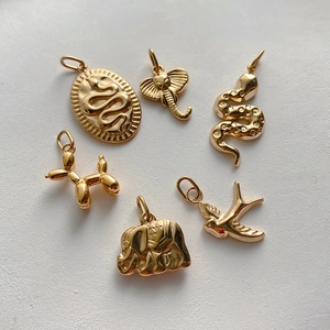 Detailed selection of gold-plated animal charms including elephant, snake, and bird shapes