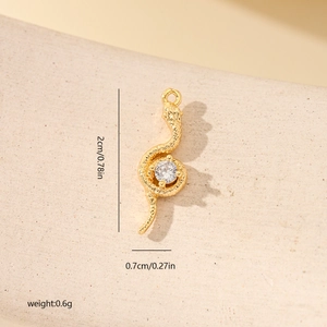 Détail d'un pendentif serpent doré avec zircon, dimensions 2cm x 0,7cm, poids 0,6g