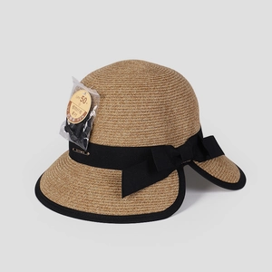 Macro detail of sun hat texture with UPF 50+ tag and elegant black bow decoration