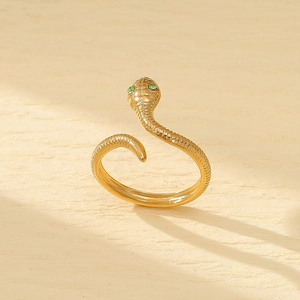 Golden snake ring with green gemstone eyes and textured wrap design in stainless steel