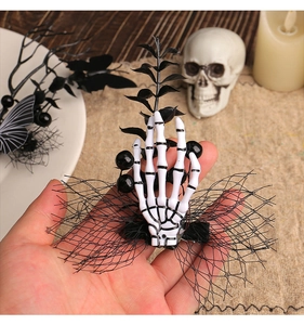 Détail d'une pince à cheveux main de squelette gothique avec résille et perles