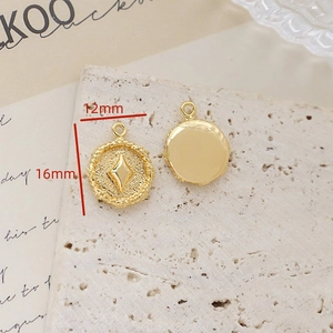 Macro view of 12mm gold starburst coin pendant showing front and back detail