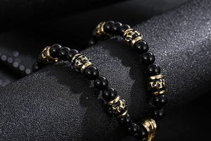 Macro view of black beads and gold star engraved charms on a retro lion necklace