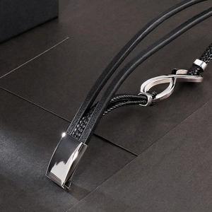 Dettaglio del bracciale in pelle intrecciata multistrato con simbolo infinito argento e fibbia