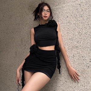 Detail of black two-piece set with 3D floral decoration and ruffled edges