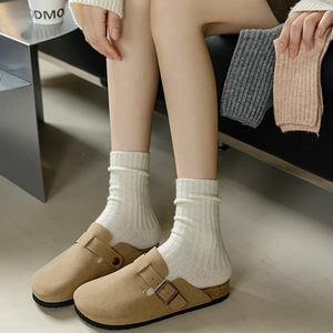 Brown suede Birkenstock-style clogs with cork sole and white ribbed knit crew socks