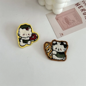 Macro detail of cartoon cat plush patches with towel embroidery and decorative textures