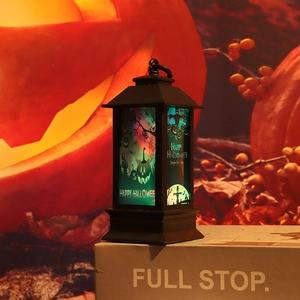 Detail of Halloween lantern featuring pumpkin and scarecrow motifs with blue light