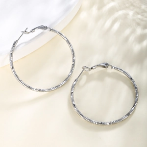 Macro shot of silver chain texture large hoop earrings with sparkling diamond pattern finish