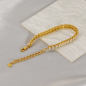 Detail of gold tennis bracelet featuring square cubic zirconia and S.Steel logo tag