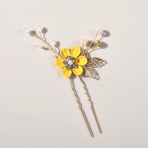 Detail of light blue beaded bridal hair pin with yellow flower and golden leaves