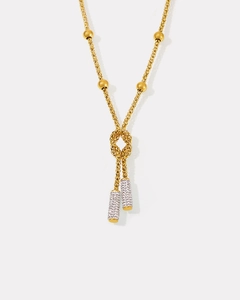 Detail of gold braided necklace with knotted design and sparkling crystal cylinder pendants