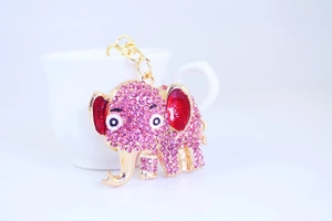 Close-up of pink rhinestone elephant keychain with gold alloy finish and red enamel detail