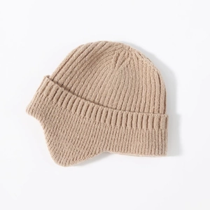 Detail of the thick ribbed knit texture and earflap design on a khaki winter beanie
