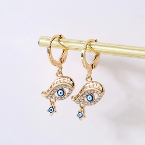 Detail von vergoldeten Evil-Eye-Ohrringen mit Zirkonia und hängenden Sternen am Ständer