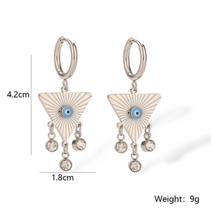 Macro detail of geometric drop earrings with blue evil eye and crystal charms