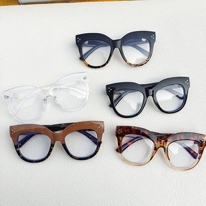 Oval cat eye glasses frames with metal rivets in five colors on stone background