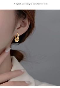 Close-up of gold tassel earrings with round disc charms on an Asian model