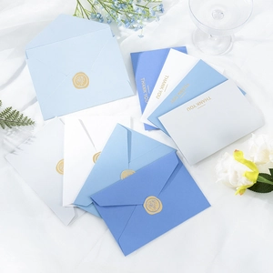 Detail of blue and white thank you cards with floral gold wax seals on white fabric