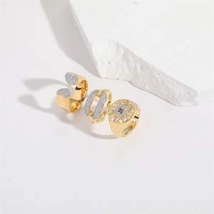 Three-piece gold heart and sunburst ring set with sparkling zircon stones in minimalist style