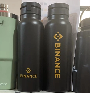 Detail of matte black vacuum insulated water bottle with printed Binance gold logo