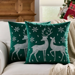 Set of two dark green velvet Christmas pillow covers with reindeer and snowflake embroidery