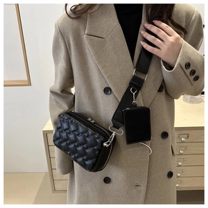 Detail of black quilted crossbody bag with adjustable strap and detachable pouch