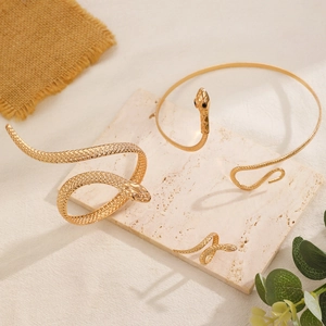 Close-up of golden snake jewelry set with detailed scale texture on stone display