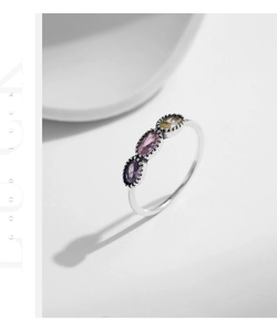 Macro detail of S925 silver ring featuring three colorful oval-cut crystals and beaded edges