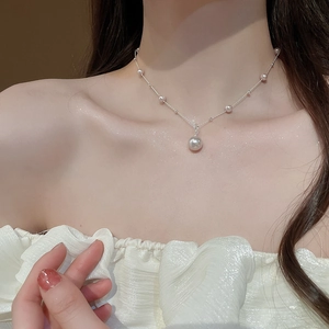 Detail of elegant irregular pearl pendant necklace on model collarbone area