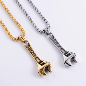 Close-up of 316L stainless steel wrench pendants in polished gold and silver finishes