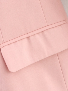 Dettaglio di un blazer in twill rosa che mostra cuciture di precisione e trama della tasca