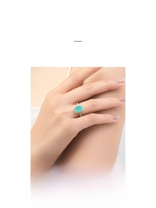 Macro shot of an elegant S925 silver ring featuring a halo-set rectangular emerald gemstone