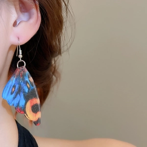 Detail of colorful acrylic butterfly wing earring on model with realistic texture