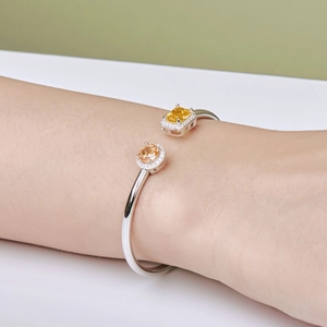 Detailed macro view of S925 silver spring bangle with yellow ice-cut zirconia stones