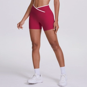 Detail of red high-waisted yoga shorts with white V-cross waistband design for fitness