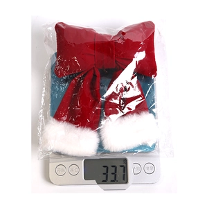 Weight measurement of a red Christmas bow ornament with white plush trim on a scale