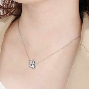 Close-up of minimalist silver puppy pendant on O-chain necklace worn by a model