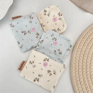 Macro detail of floral corduroy pouches with snap button closure and woven label