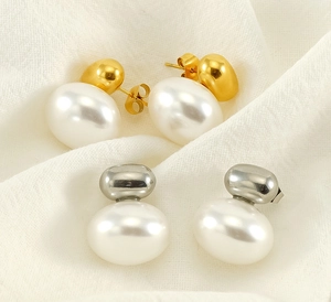 Detail of vintage French style 18K gold and silver pearl earrings on white fabric