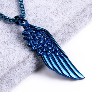 Macro shot of dark blue titanium steel feather pendant with detailed texture on velvet