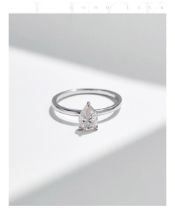 Close-up of s925 silver pear-shaped moissanite ring on minimalist white blocks