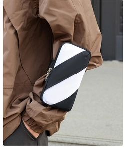 Close-up of sports arm bag with black and white stripes and durable metal zipper