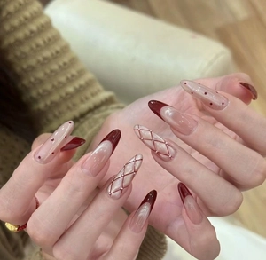 Close-up of French red cat-eye press-on nails with diamond pattern and pearl accents