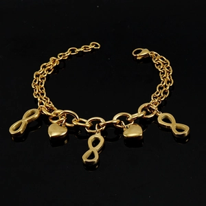 Bracelet doré en acier 18K avec symboles cœur et infini sur une surface noire lisse
