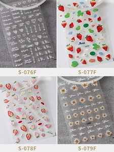 Detailed macro view of 3D embossed nail art stickers with floral and strawberry designs